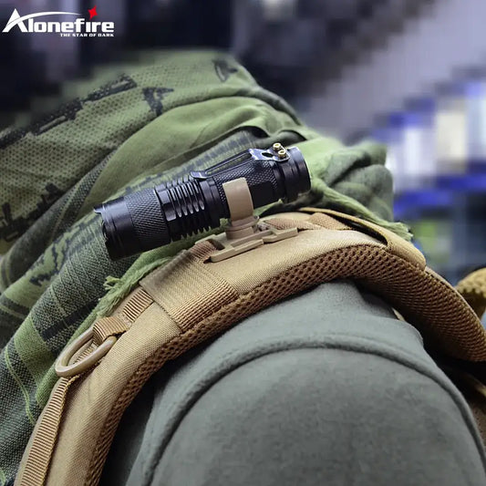 Tactical flashlight attached to a military-style backpack strap.