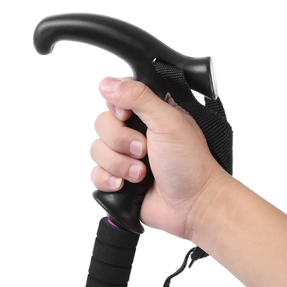 Black walking cane with a curved handle gripped by a hand.