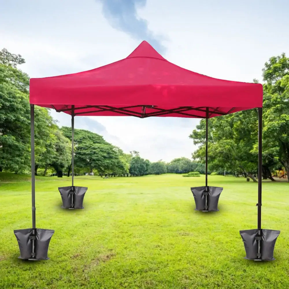 Red pop-up canopy tent with weight bags on each leg.