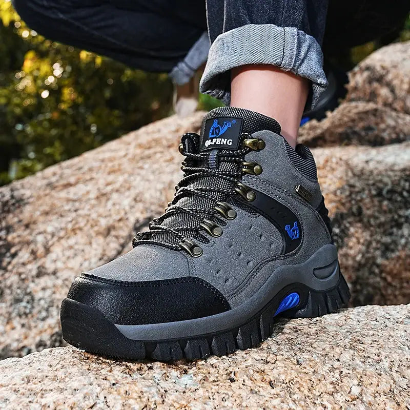 Rugged hiking boot with gray and black coloring and blue accents.