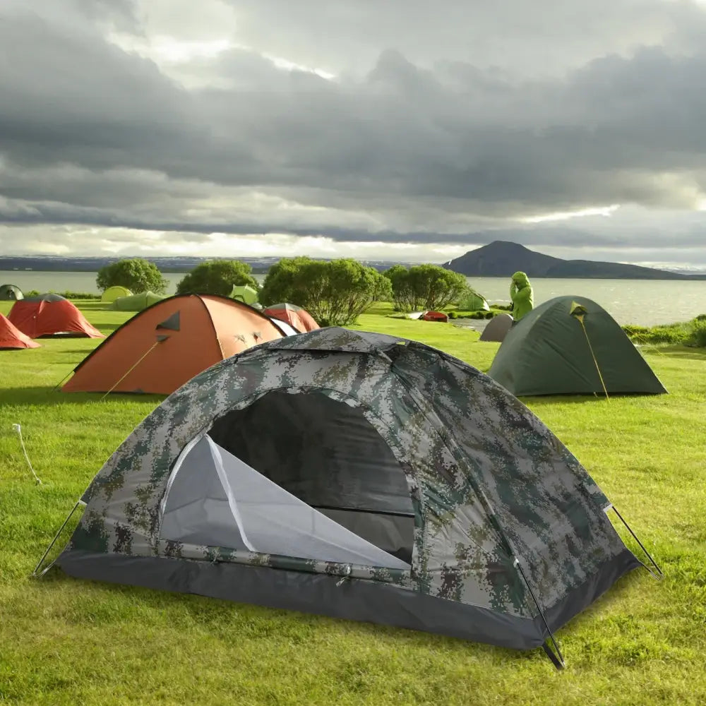 Camouflage-patterned camping tent on grassy ground.