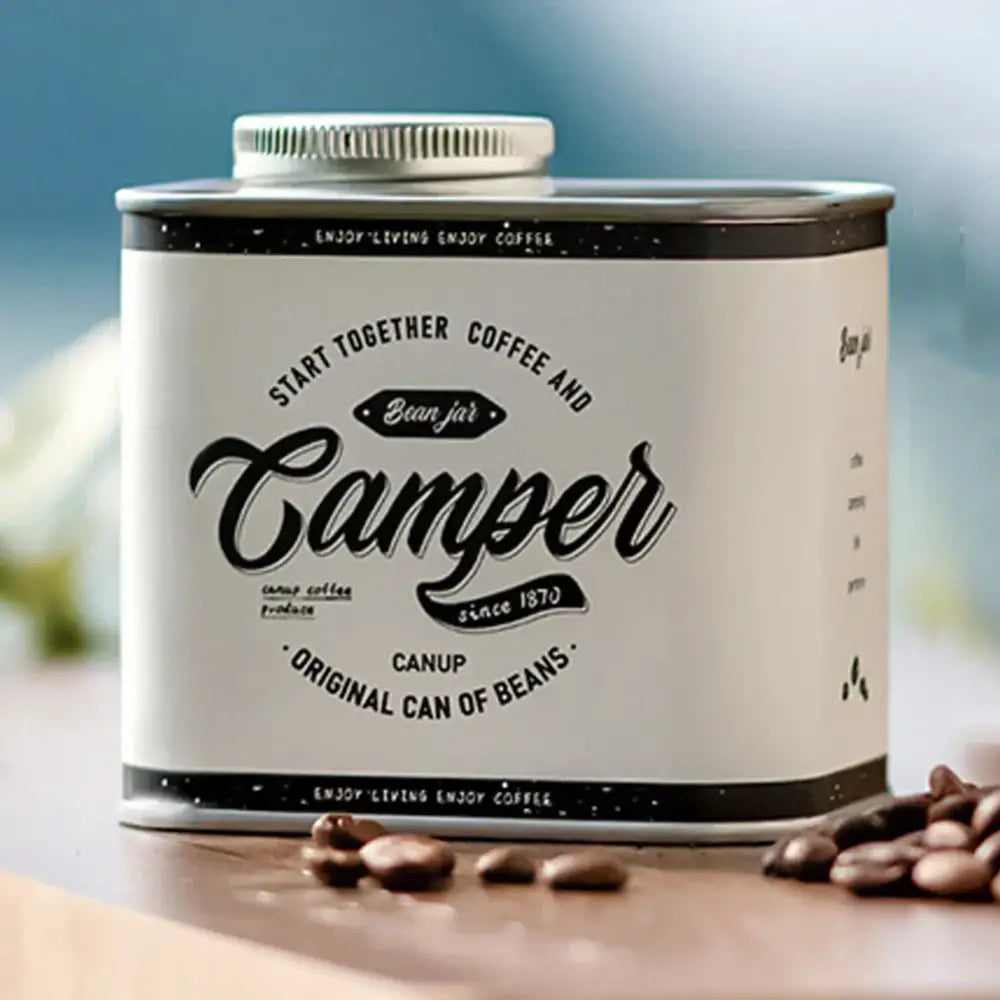 Vintage-style metal can labeled ’Camper’ containing coffee beans.