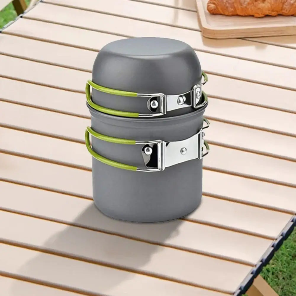 Compact camping cookware set with gray pots and green straps.