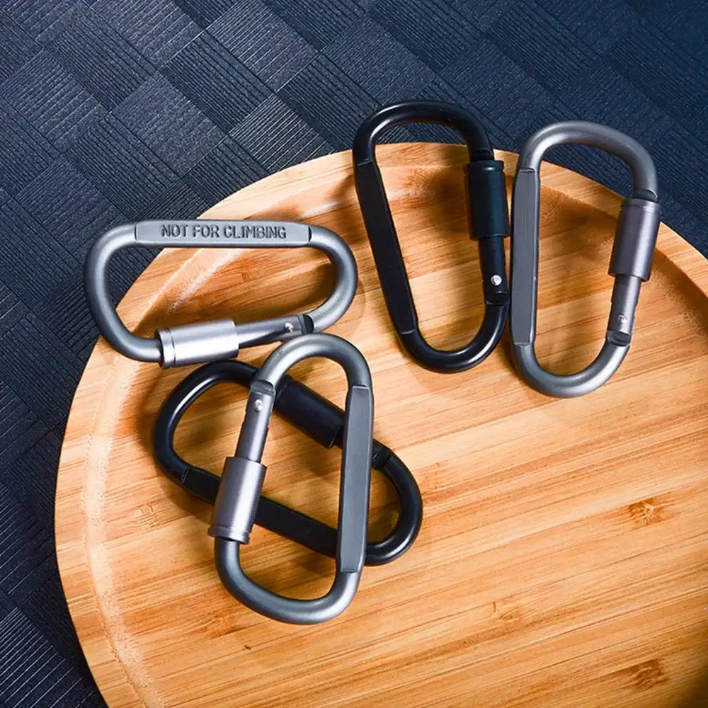 Carabiners or climbing hooks on a wooden cutting board.