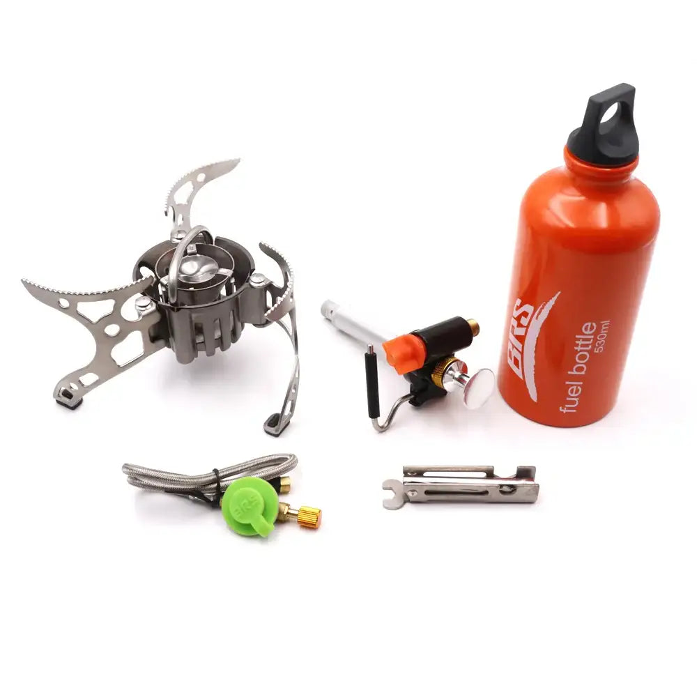 Portable camping stove with fuel bottle and accessories.