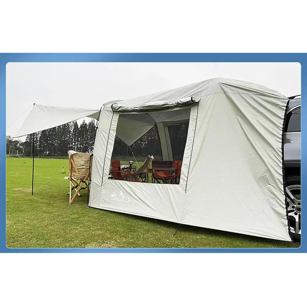 Canvas tent with a window and awning set up on grass.