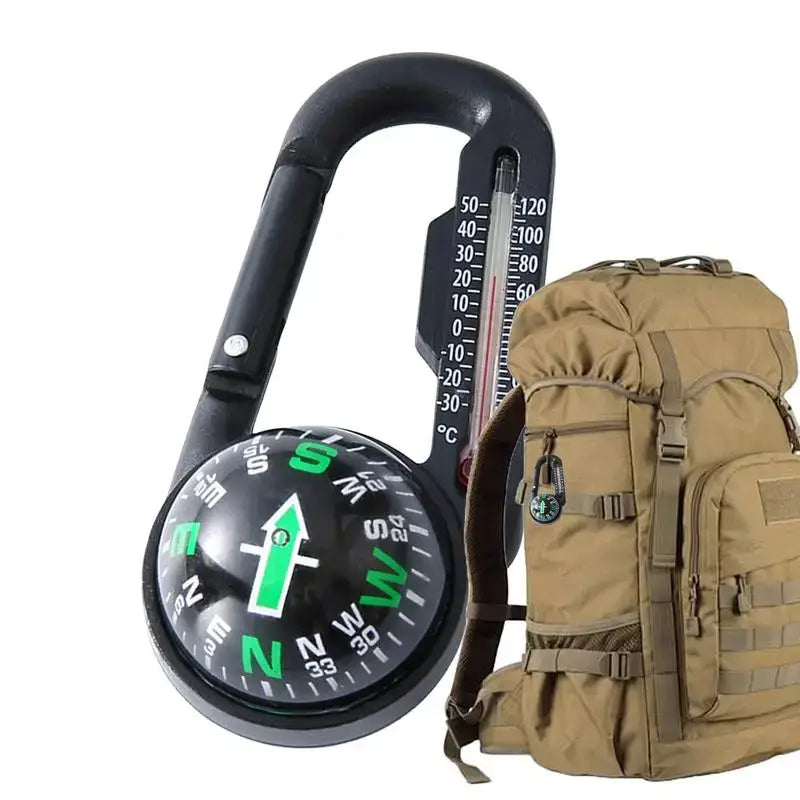 Carabiner-style compass with attached thermometer next to a tan tactical backpack.