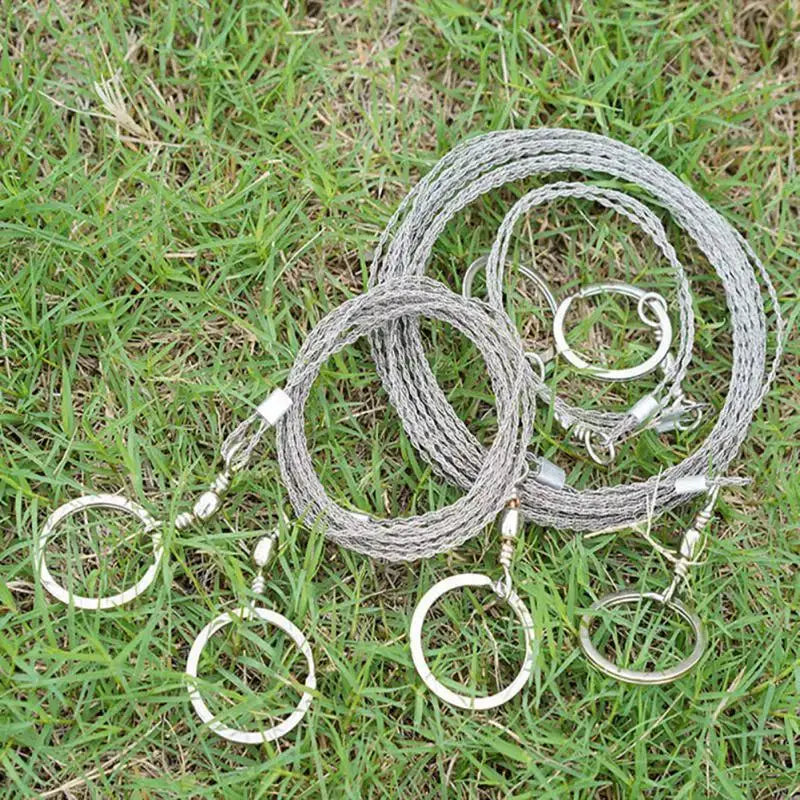 Coiled metal wire snares or traps lying on grass.