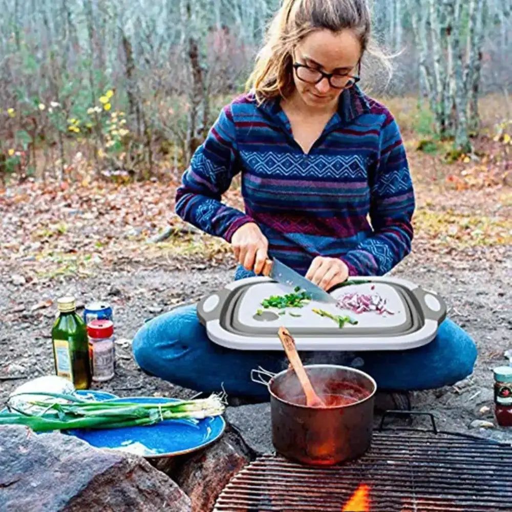 Person preparing food outdoors while camping.