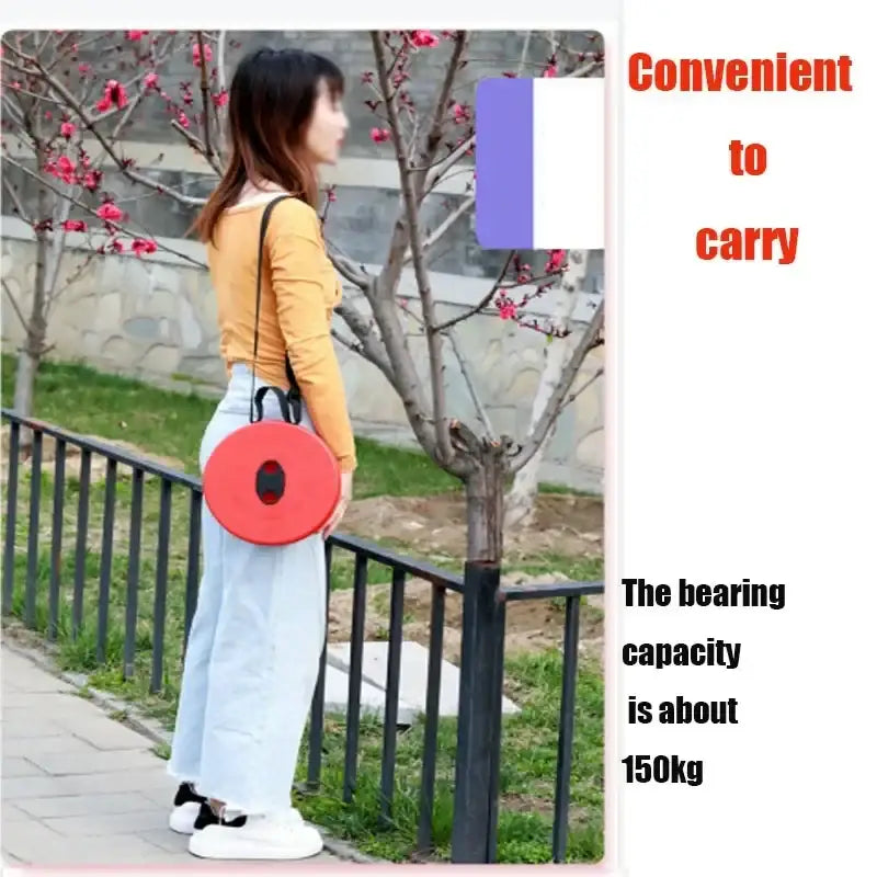 Circular red cushion or seat with a carrying strap.