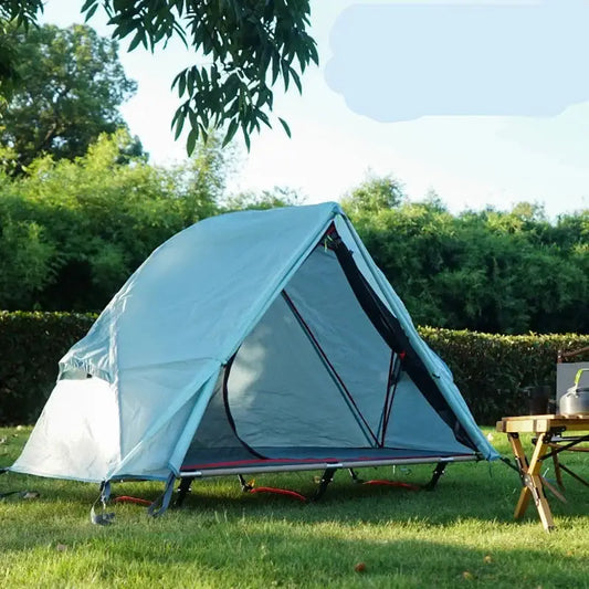 Light blue camping tent set up on grass.