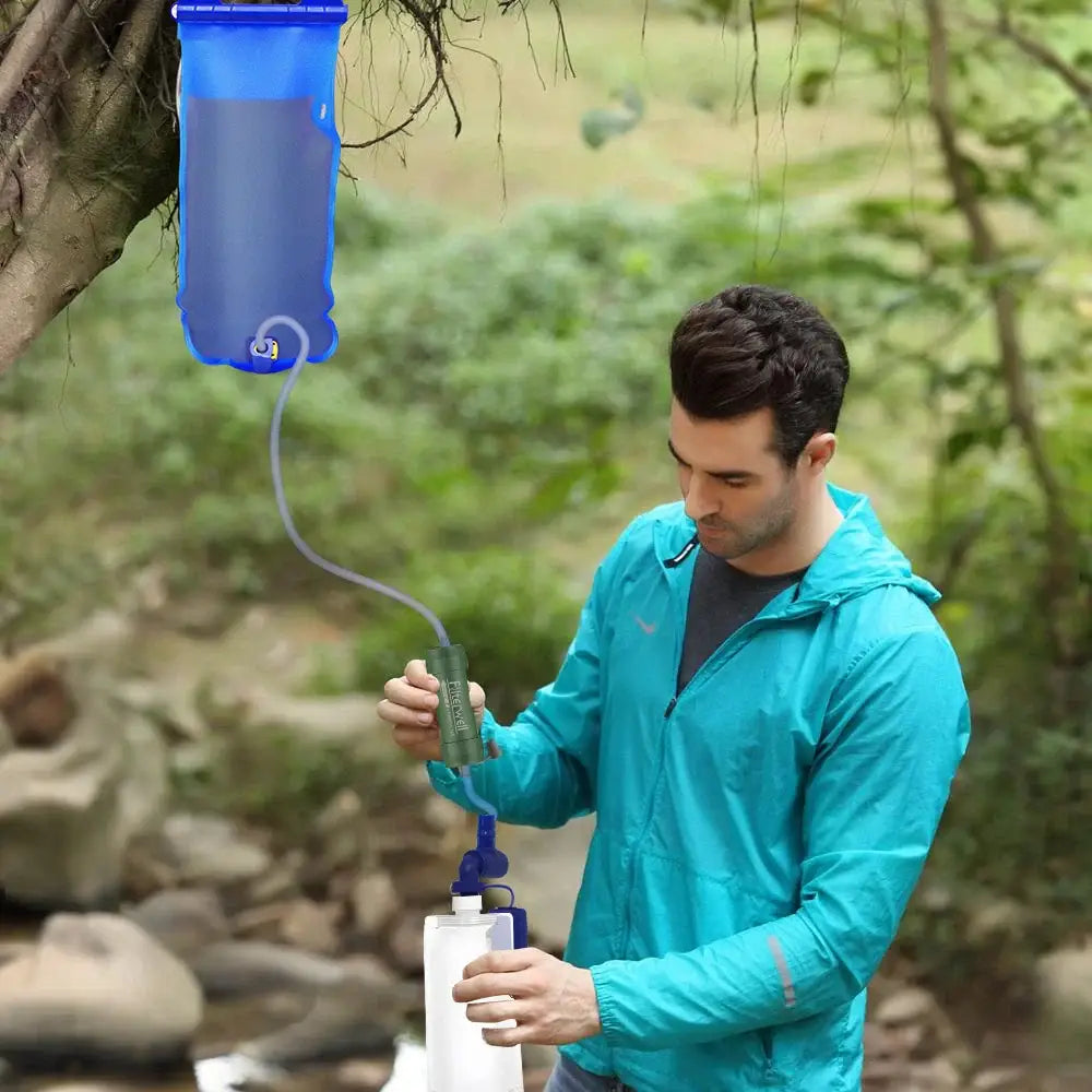 Water filtration system being used outdoors by a person in a teal jacket.