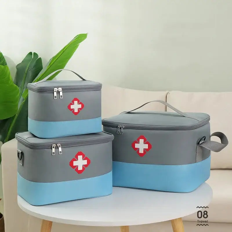 Set of three gray and blue first aid kits with red cross symbols.