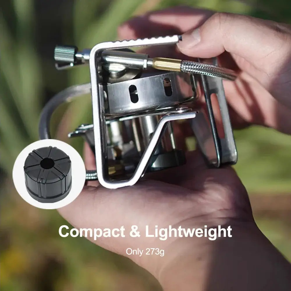 Compact portable camping stove being held in a hand.