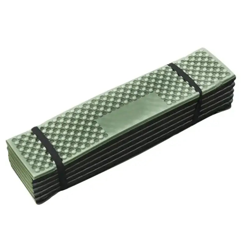 Folding foam camping mat with textured surface and elastic straps.