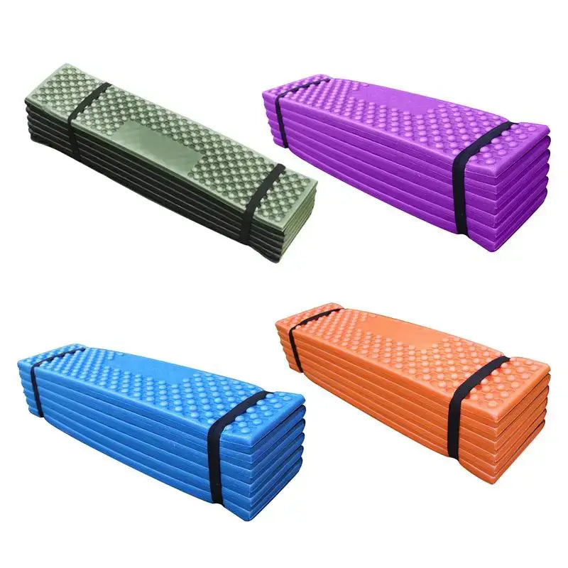 Folding foam camping mats in various colors secured with straps.