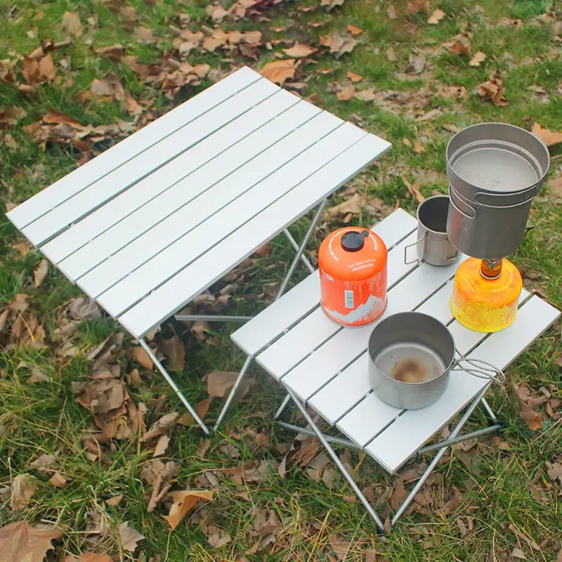 Folding camping table with cooking equipment on top.