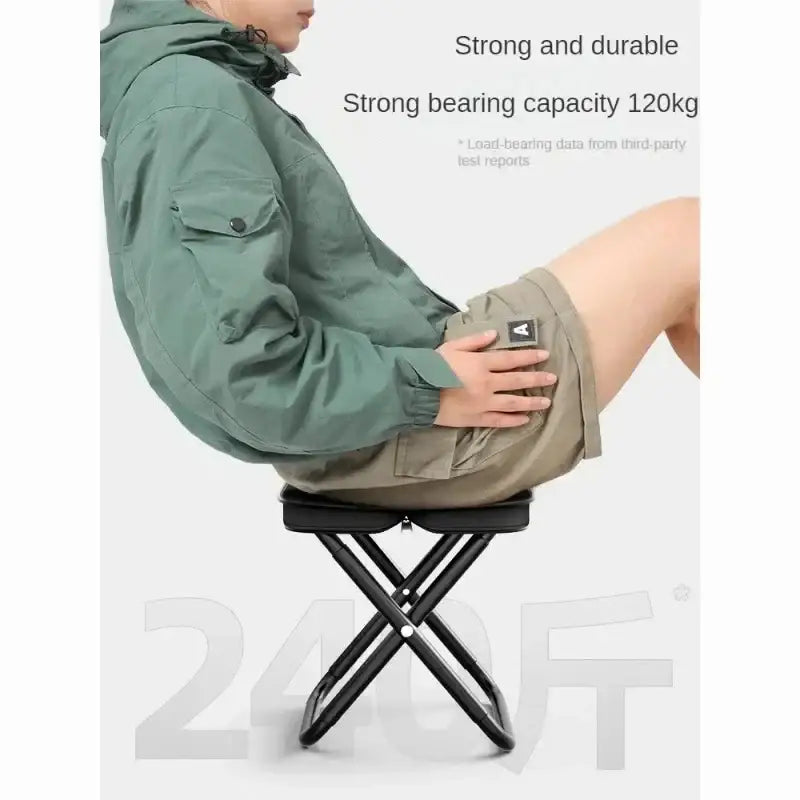 Folding stool with a person seated to demonstrate its strength and durability.