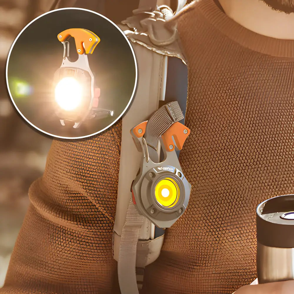 Illuminated clip-on safety light with an orange pull tab attached to fabric.