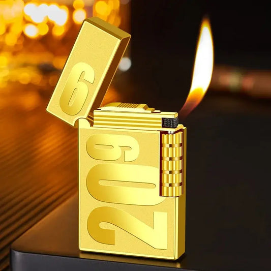 Gold-colored lighter with ’2023’’ engraved on its side, open and lit.