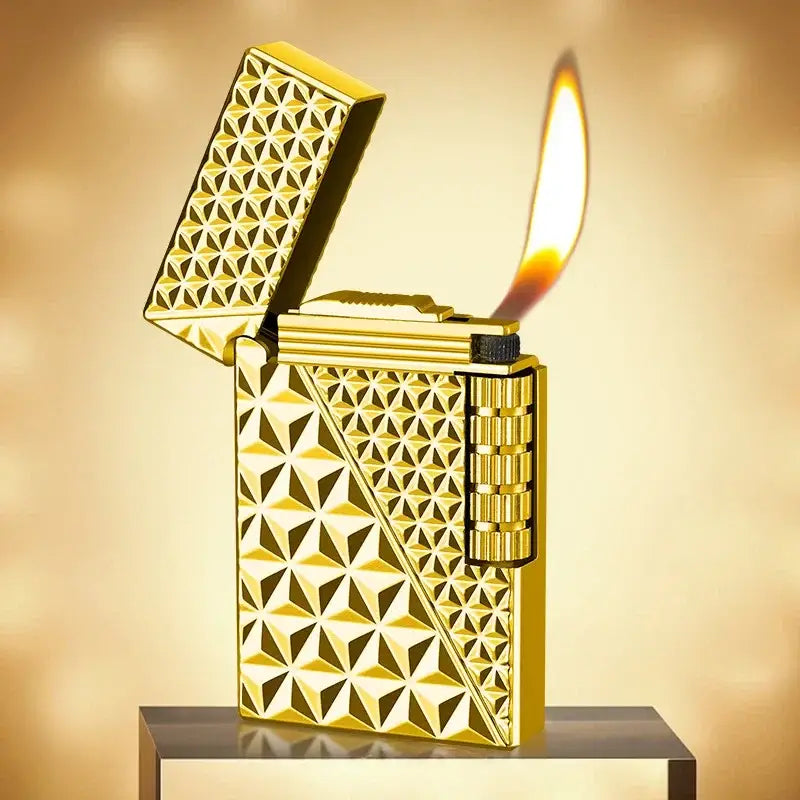 Golden lighter with an intricate geometric pattern engraved on its surface, shown lit with a flame.