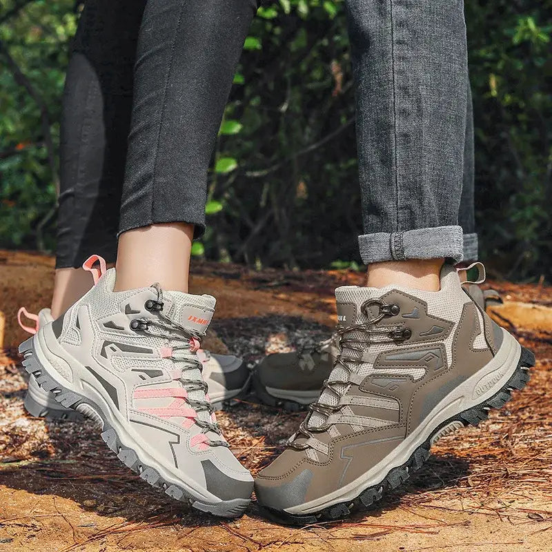 Pair of hiking boots worn by someone standing on a forest trail.