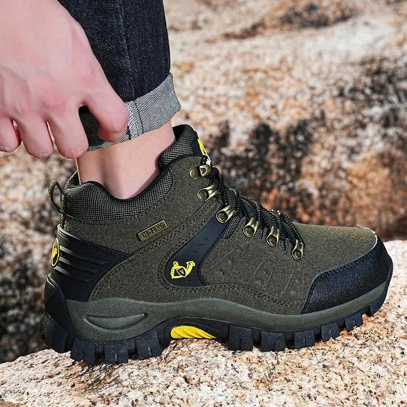 Rugged hiking boot with olive green upper and yellow accents.