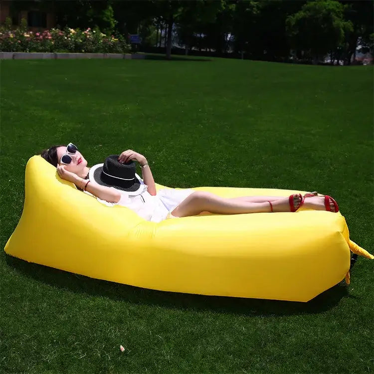 Bright yellow inflatable lounger or air sofa on grass.