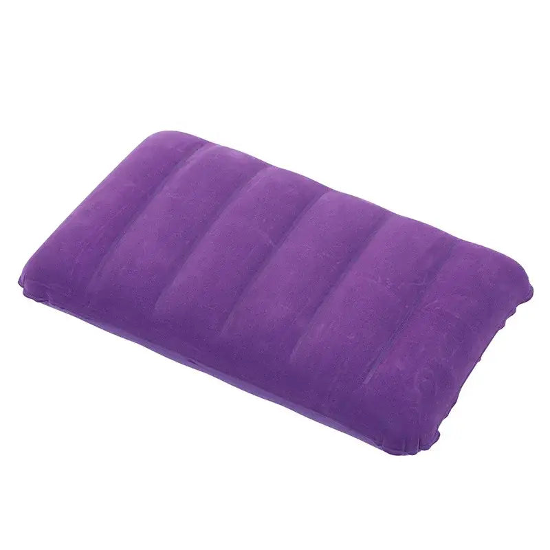 Purple inflatable travel pillow with ribbed surface.