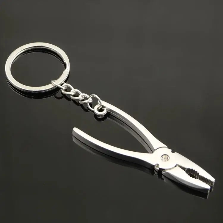 Metallic pliers-shaped keychain with a ring attachment.