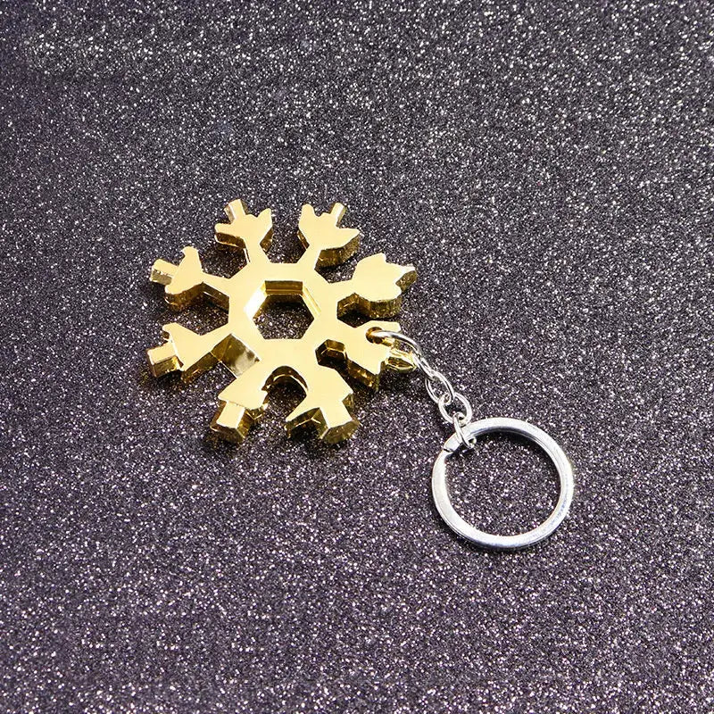 Gold-colored snowflake-shaped keychain charm.