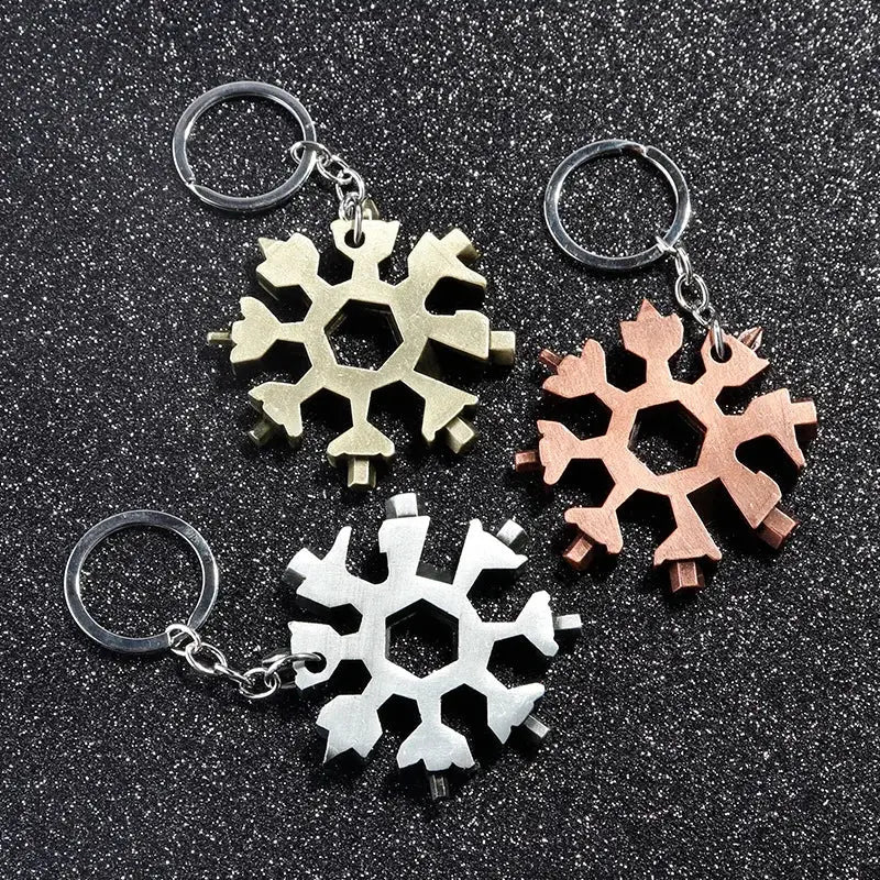 Snowflake-shaped keychains in metallic gold, rose gold, and silver colors.