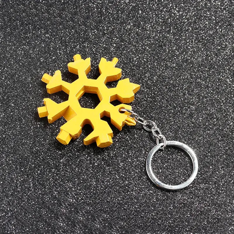 Yellow snowflake-shaped keychain with a metal ring attached.