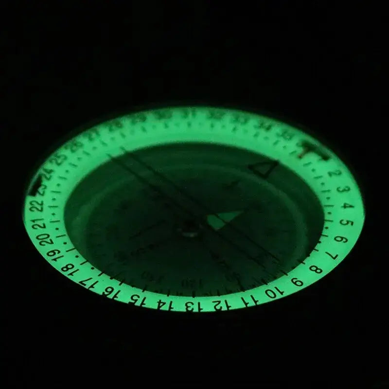 Handheld military-style compass with a circular sighting lens and degree markings.