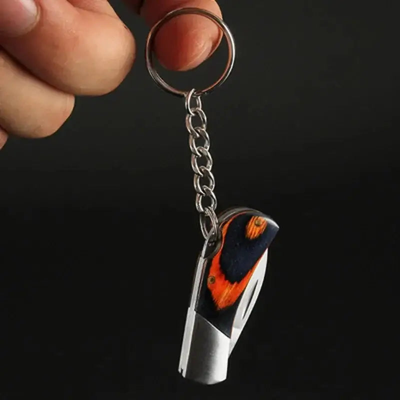 Keychain with a silver and orange whistle attached to a metal chain.