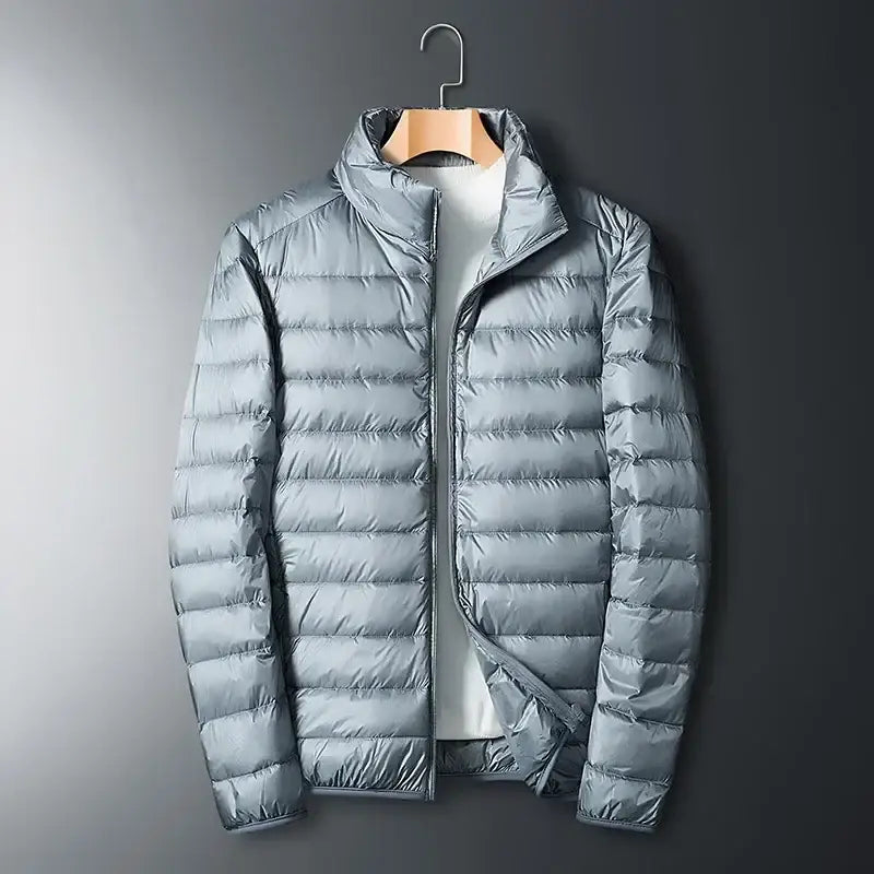 Light gray puffy down jacket hanging on a wooden hanger.