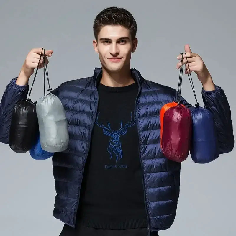 Young man wearing a blue puffer jacket and holding multiple colorful bags.