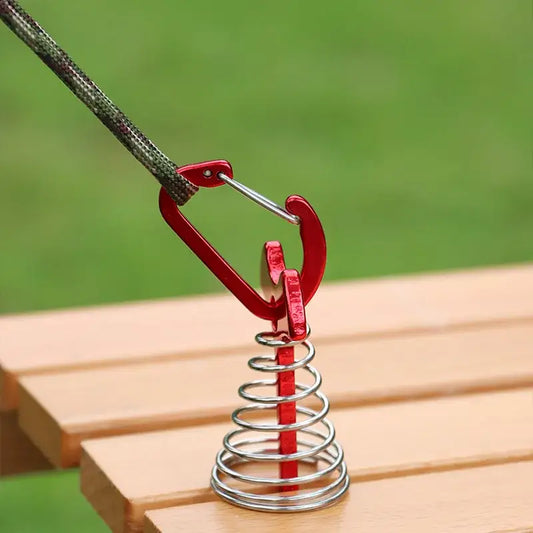 Red carabiner attached to a metal coil spring.