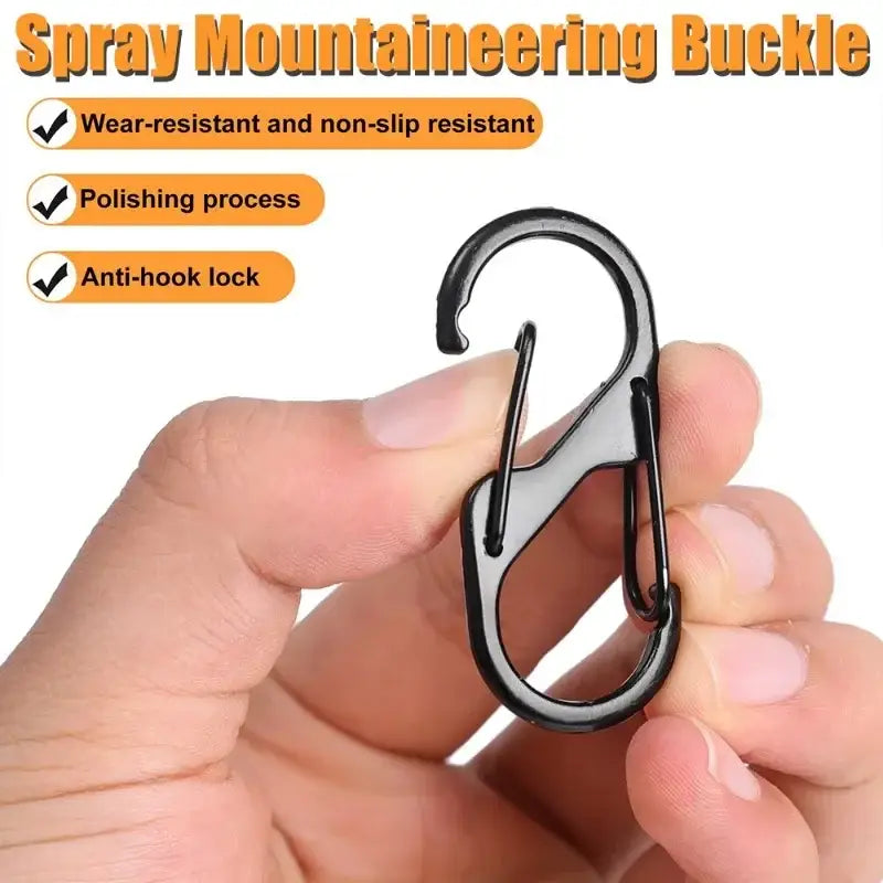 Metallic carabiner-style mountaineering buckle held between fingers.