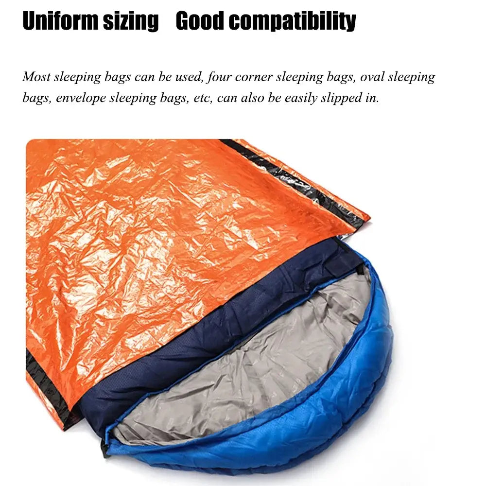 Emergency sleeping bag or bivvy sack with an orange exterior and blue interior.