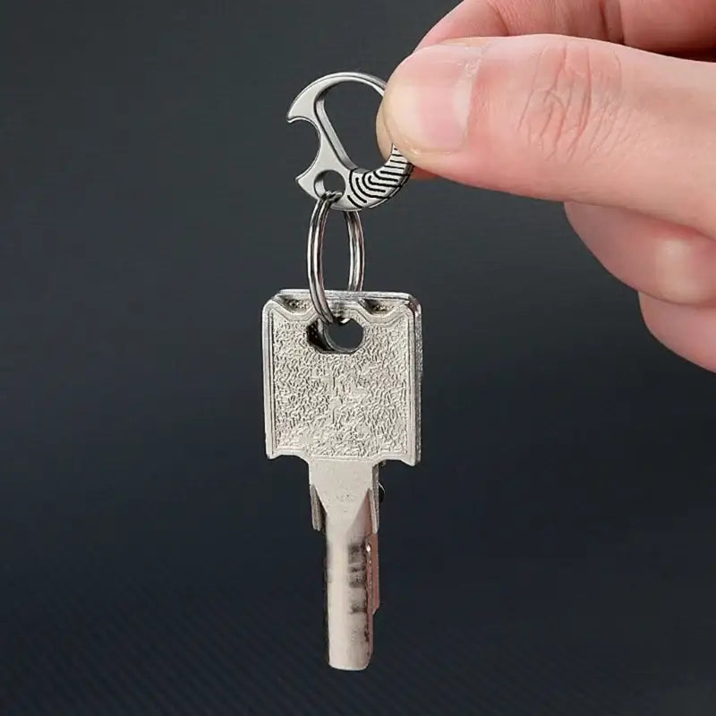 Metal key with a decorative wing-shaped keychain attachment.