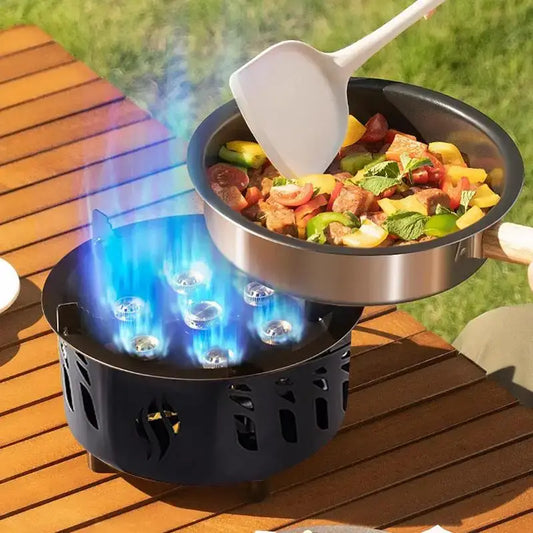 Portable gas stove with a frying pan cooking a colorful stir-fry dish.