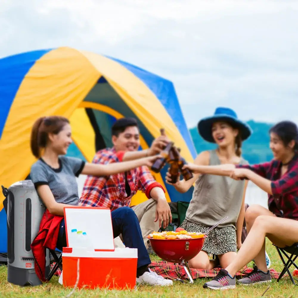 Group of friends enjoying a camping picnic with tents and coolers.