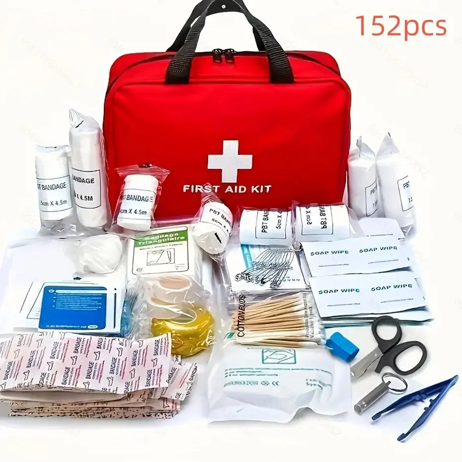 Red first aid kit bag with various medical supplies spread out in front of it.