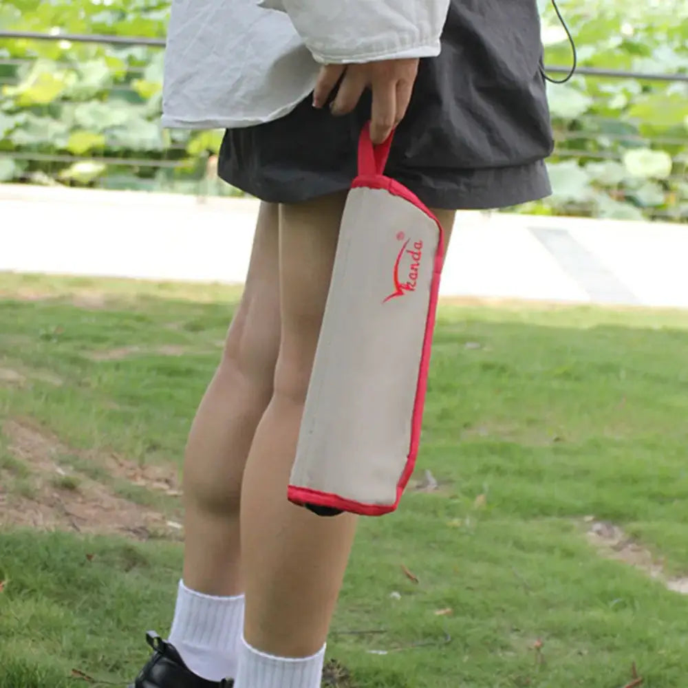 Portable water bottle holder with a red trim and strap.