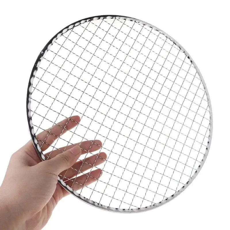 Circular wire mesh or grill grate held by a hand.