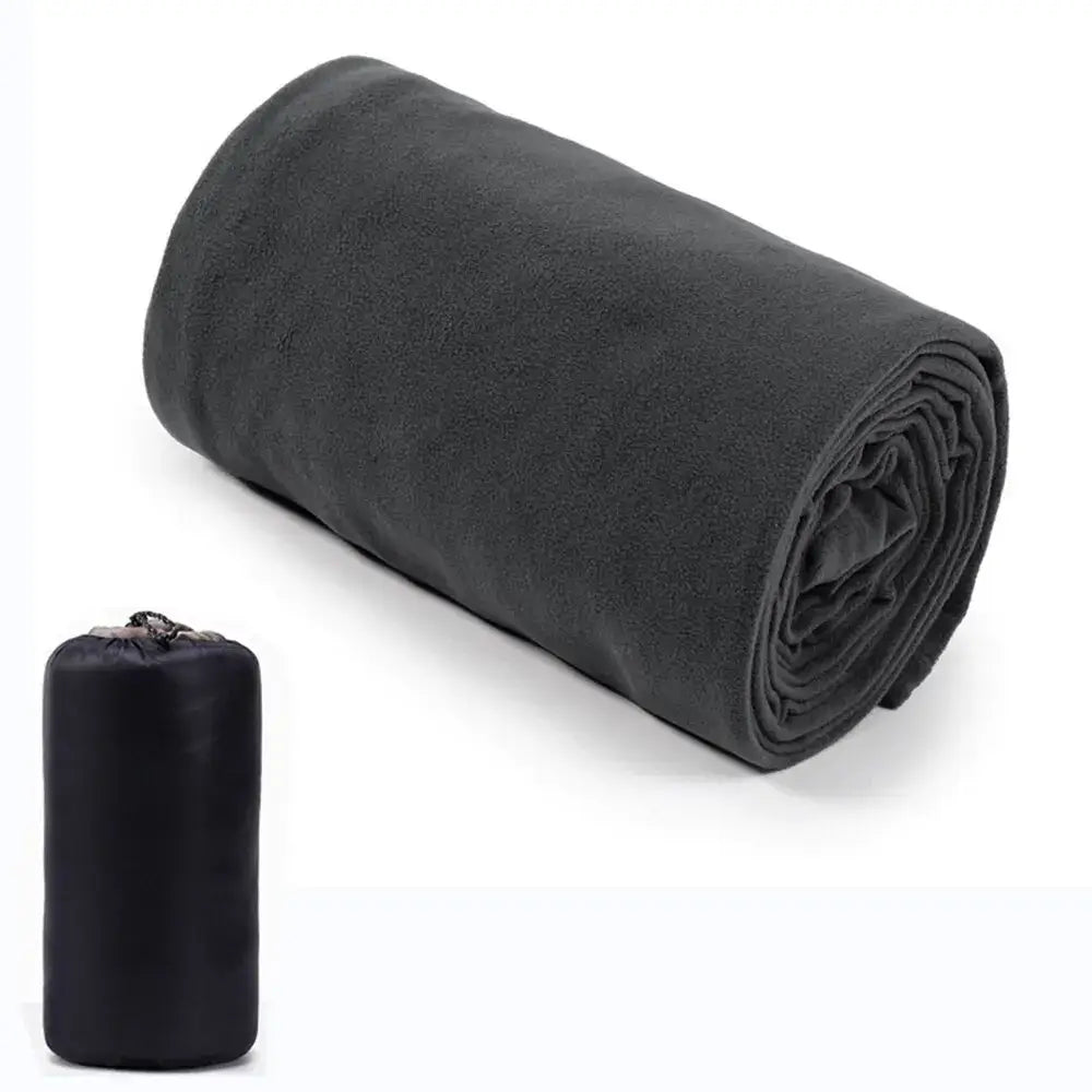 Rolled-up black fleece blanket or sleeping bag with a compact storage pouch.