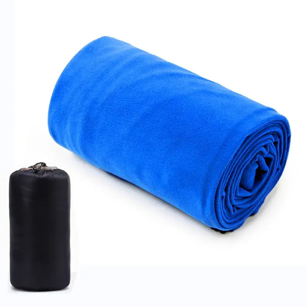 Rolled-up bright blue fleece blanket or sleeping bag next to a black carrying pouch.