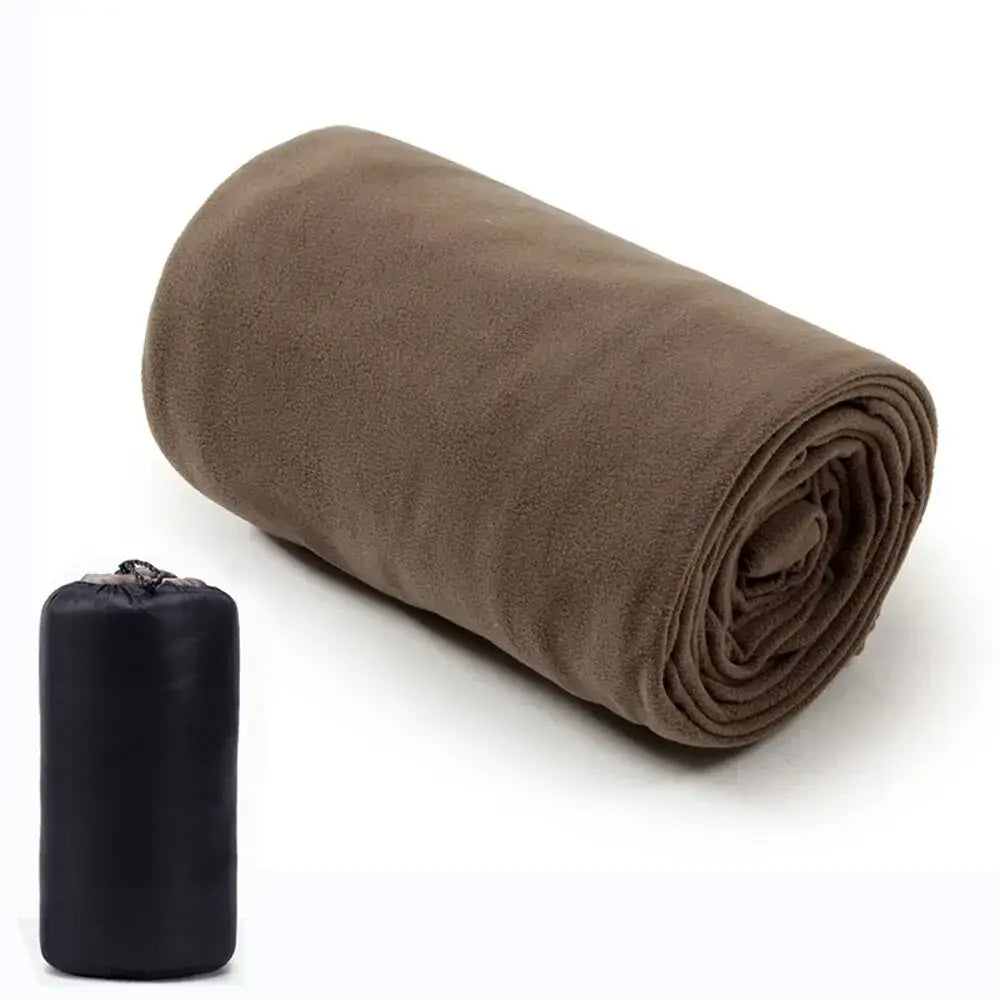 Rolled-up brown fleece blanket next to a small black storage bag.