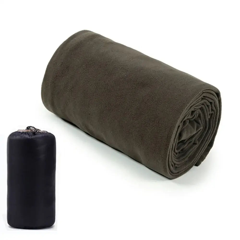 Rolled-up olive green sleeping bag or camping blanket next to its black storage bag.